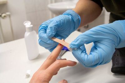 doctor sticks a plaster on a finger